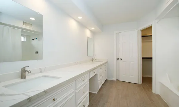 a bathroom with a double vanity sink and a mirror
