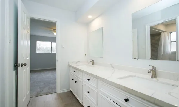a bathroom with a double vanity sink and mirror