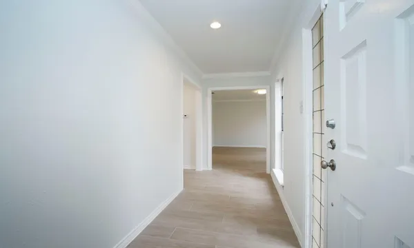 a view of a hallway with wooden floor and closet