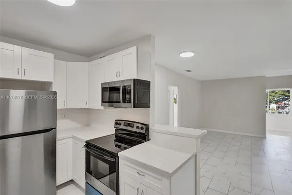 a view of a kitchen with white cabinets