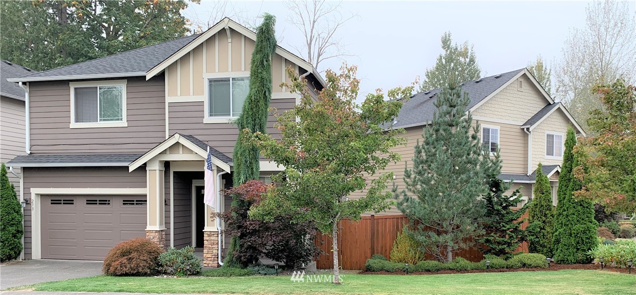 273 Graham Avenue Northeast Renton, WA 98059 - Photo 2 of 23 a front view of a house with a yard and trees