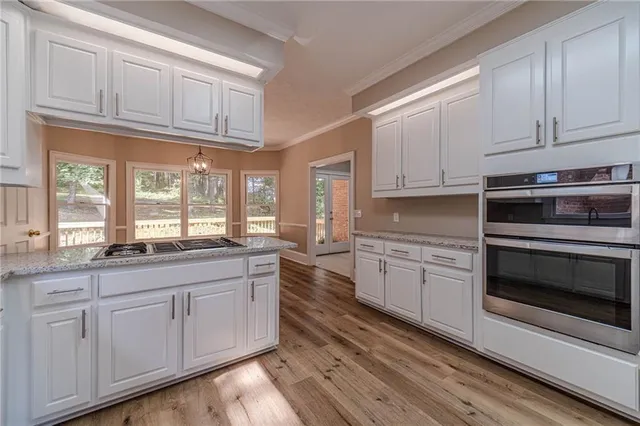 a kitchen with granite countertop cabinets stainless steel appliances and a window