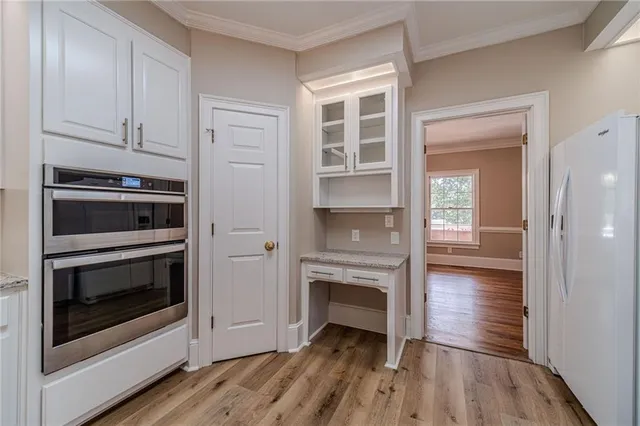 a view of kitchen and hallway with wooden floor
