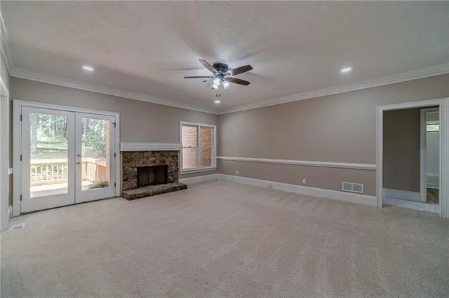an empty room with fireplace and windows