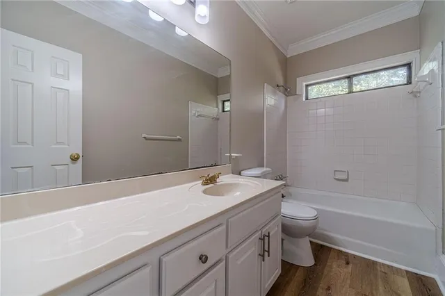 a bathroom with a granite countertop sink a toilet and bathtub