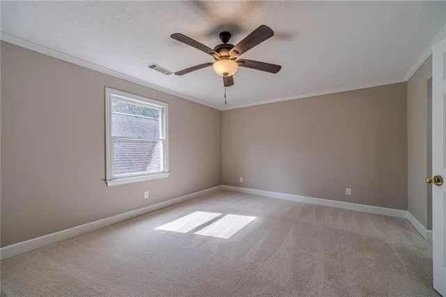 an empty room with windows and fan
