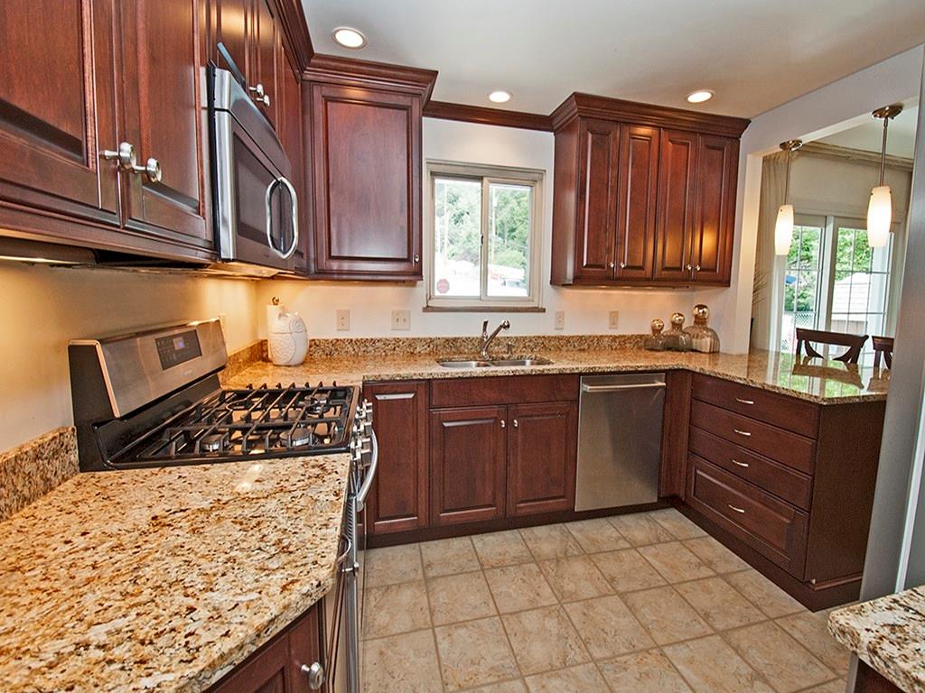 15 Winding Road Leetsdale, PA 15056 - Photo 8 of 18 Renovated with the chef in mind, this kitchen has beautiful custom cabinets, granite countertops, a gas stove & a refrigerator with a TV screen on the door!