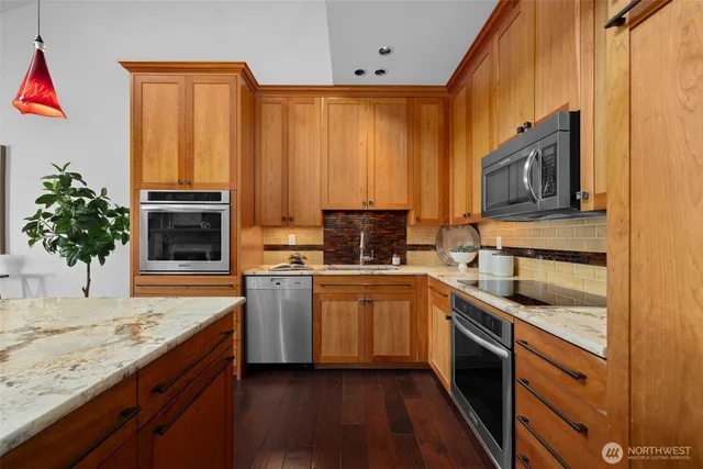 a kitchen with stainless steel appliances granite countertop a stove a sink and a microwave