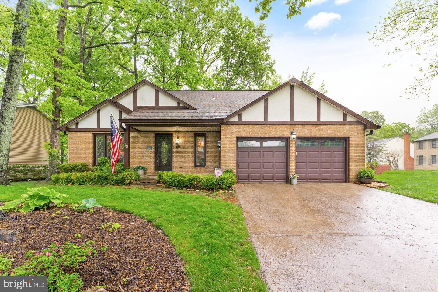 Charming brick home with lush greenery.