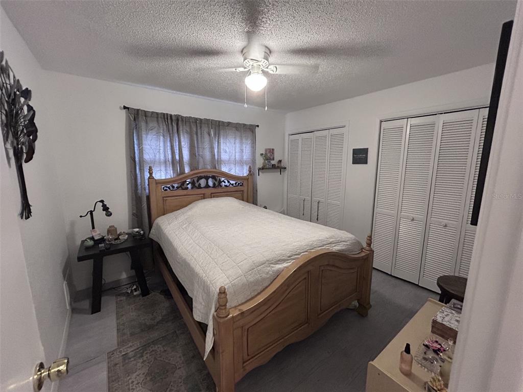 1495 Bishop Road Spring Hill, FL 34608 - Photo 13 of 34 a spacious bedroom with a bed and a chandelier