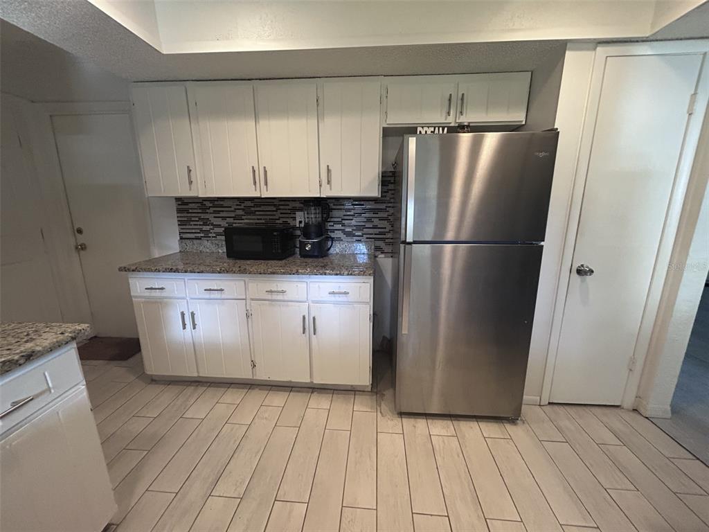 1495 Bishop Road Spring Hill, FL 34608 - Photo 25 of 34 a white refrigerator freezer sitting inside of a kitchen