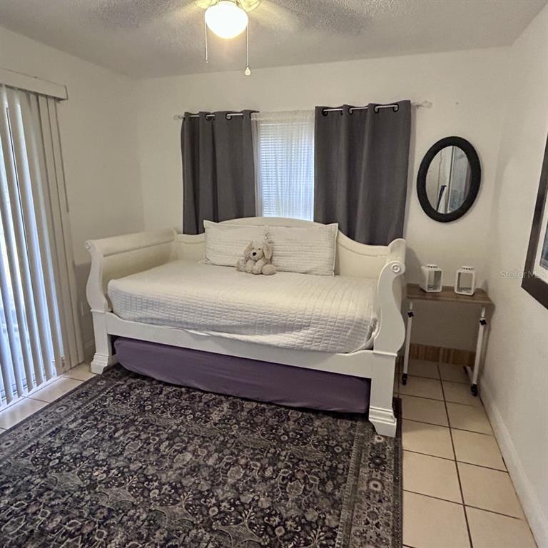 1495 Bishop Road Spring Hill, FL 34608 - Photo 26 of 34 a bedroom with a bed and a chandelier