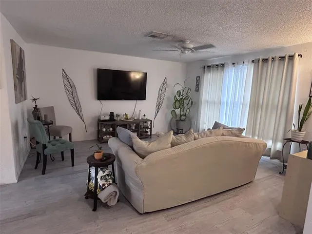 a living room with furniture a flat screen tv and a window