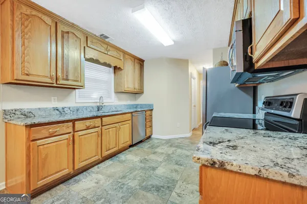 a kitchen with stainless steel appliances granite countertop a sink stove and cabinets