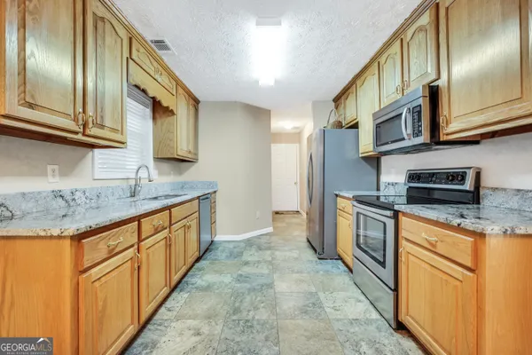 a kitchen with stainless steel appliances granite countertop a sink and cabinets