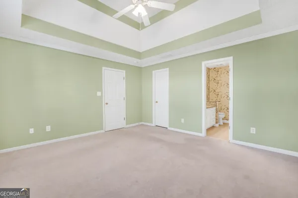 a view of an empty room with a chandelier fan