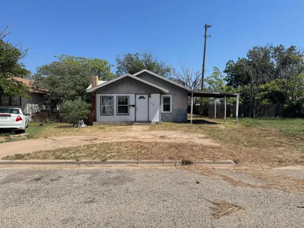 a front view of a house with a garden and yard