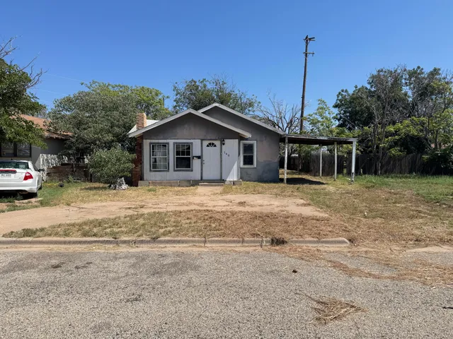 a front view of a house with a garden and yard