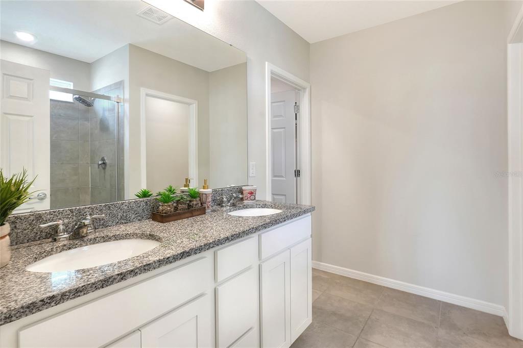 1623 Aspen Avenue Davenport, FL 33837 - Photo 21 of 43 a bathroom with a granite countertop sink and a mirror