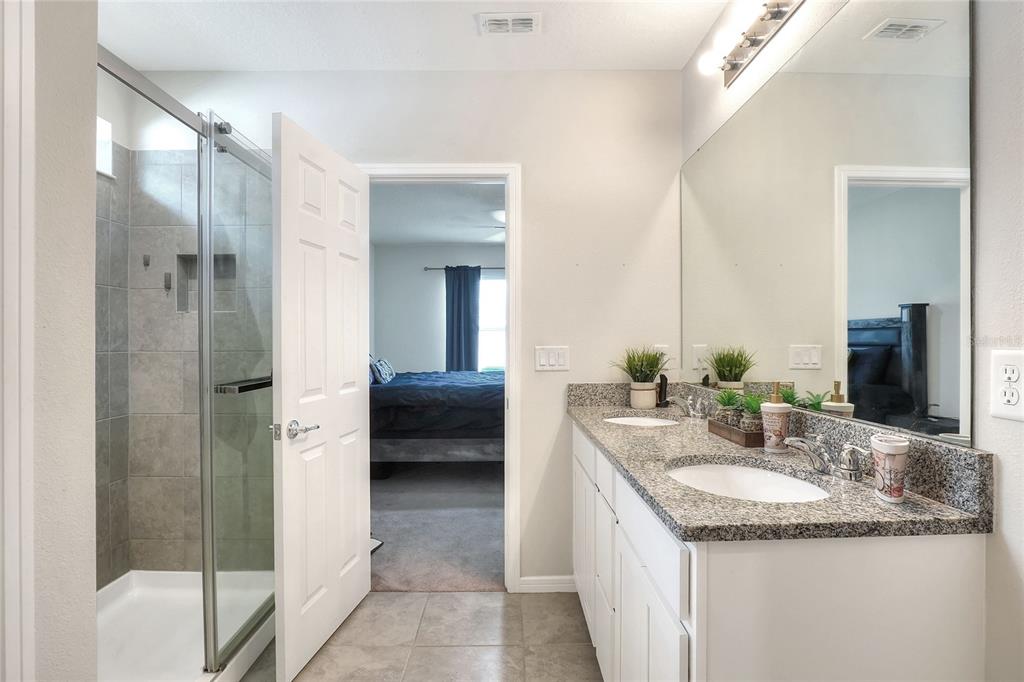 1623 Aspen Avenue Davenport, FL 33837 - Photo 23 of 43 a bathroom with a granite countertop sink and a mirror