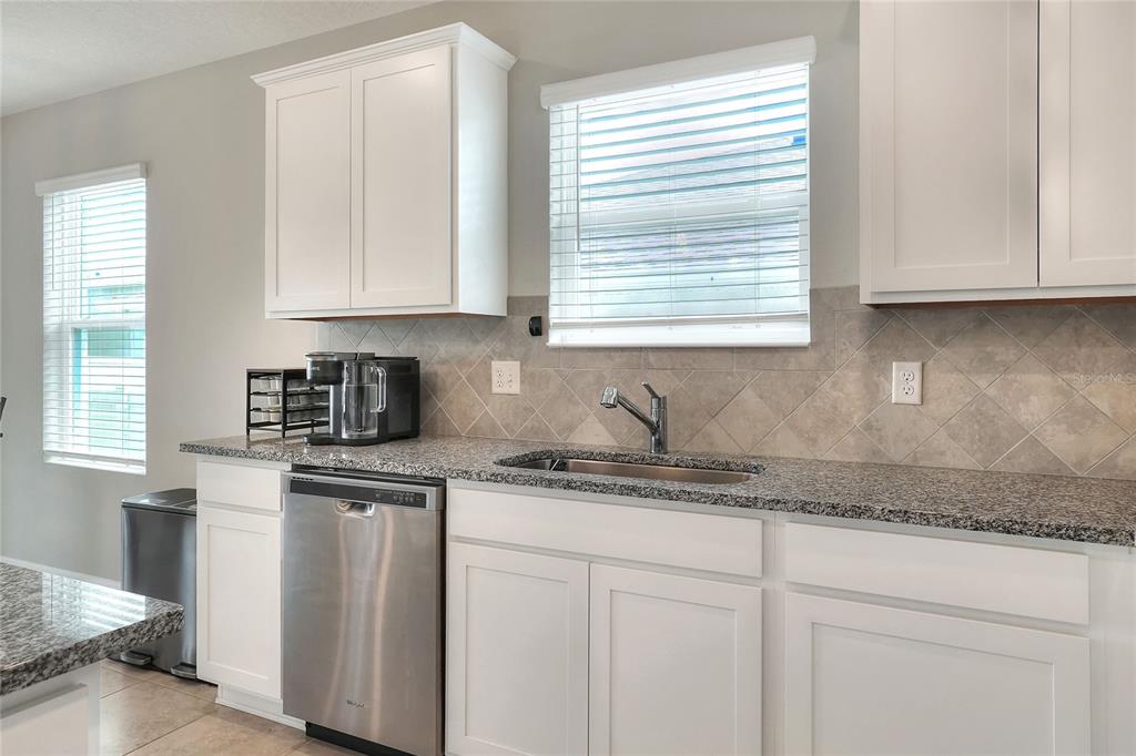 1623 Aspen Avenue Davenport, FL 33837 - Photo 6 of 43 a kitchen with granite countertop white cabinets and a sink