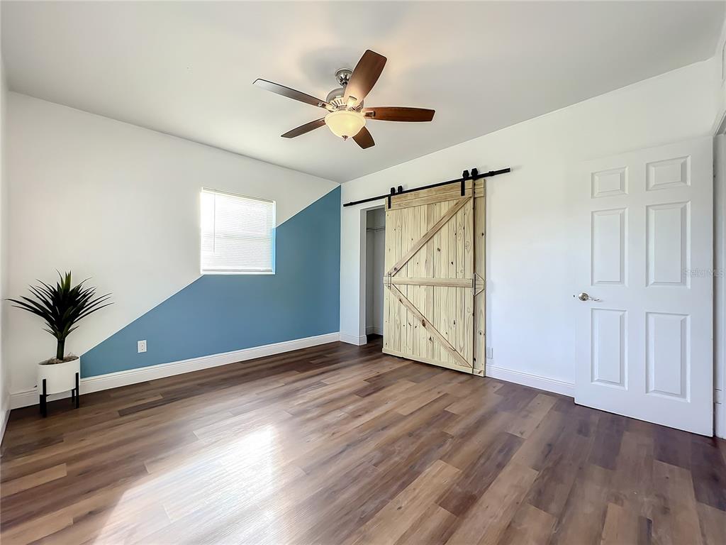 1613 Perkins Road Belle Isle, FL 32809 - Photo 18 of 37 Beautiful bright Master Bedroom. New vinyl flooring, fresh paint, new blinds, ceiling fanlight, and custom barn doors on master closet. This view is looking in master from en suite bath doorway.