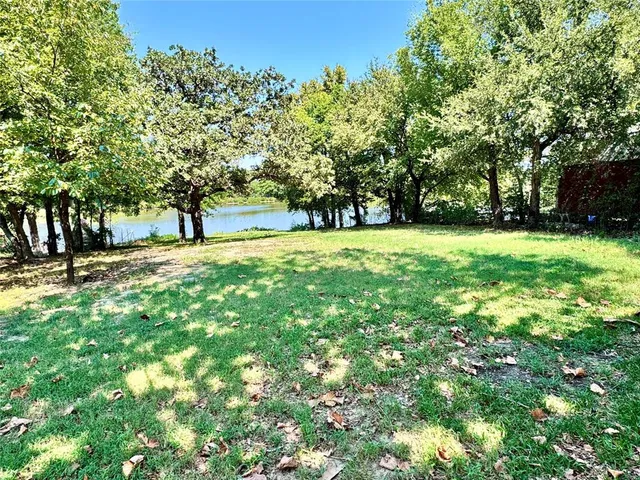 a big yard with trees in front of it