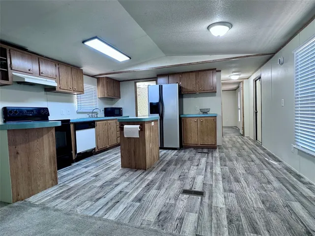 a kitchen with stainless steel appliances kitchen island wooden cabinets and granite counter tops