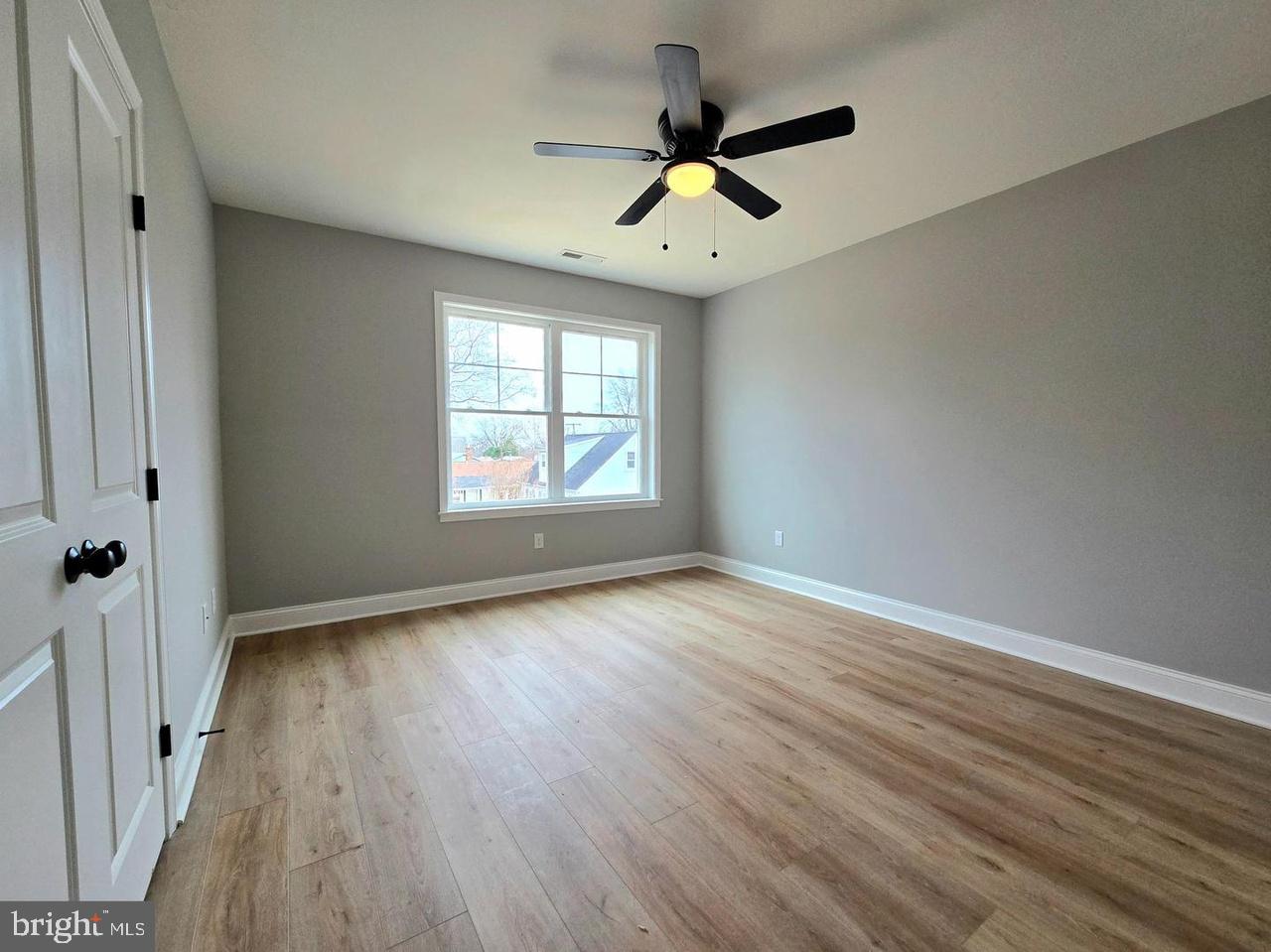 8478 Garden Road Pasadena, MD 21122 - Photo 12 of 14 wooden floor in an empty room with a window