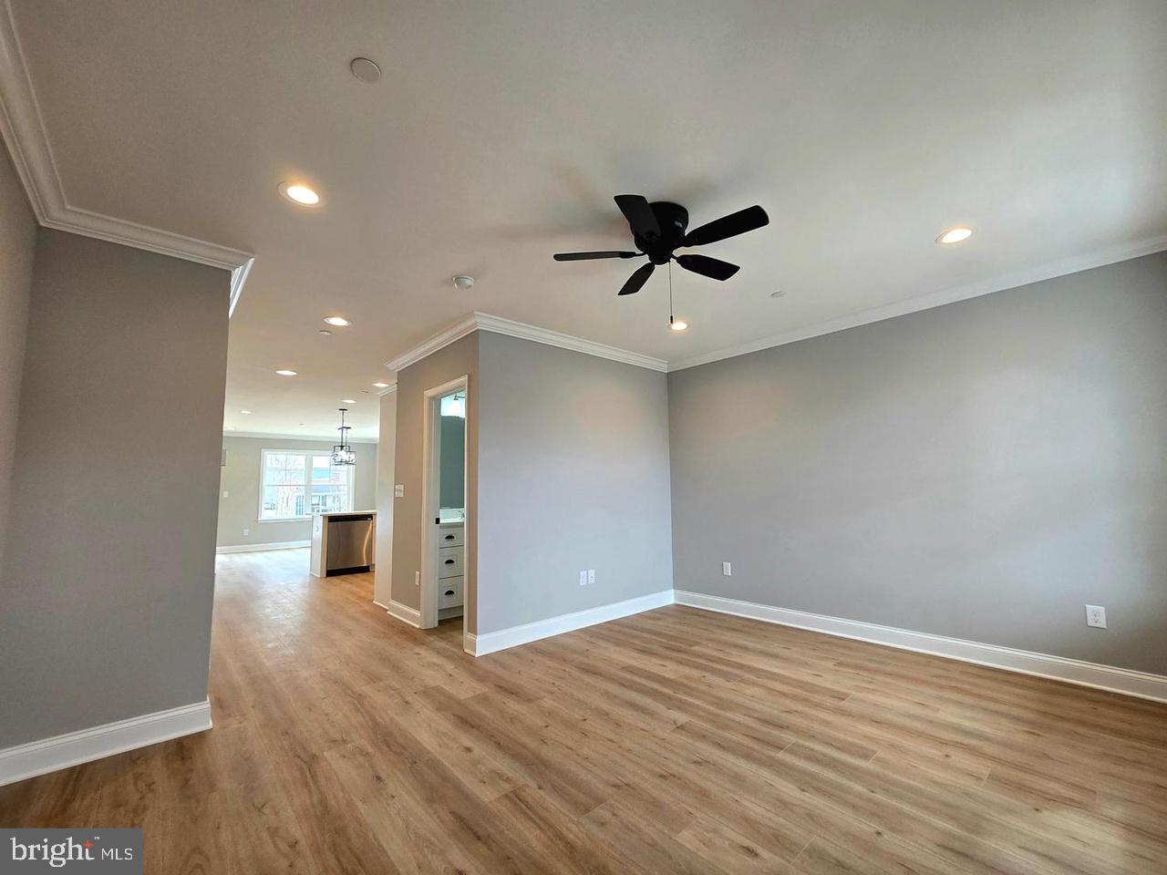 8478 Garden Road Pasadena, MD 21122 - Photo 5 of 14 an empty room with wooden floor and a ceiling fan