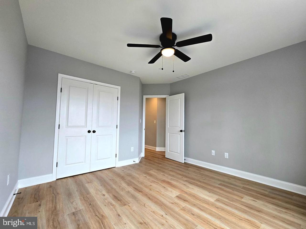 8478 Garden Road Pasadena, MD 21122 - Photo 10 of 14 a view of empty room with wooden floor and fan