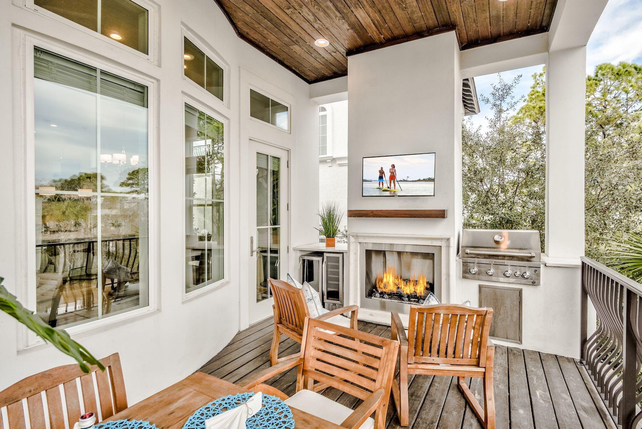 81 Palmeira Way Santa Rosa Beach, FL 32459 - Photo 28 of 74 a view of a patio with couches table and chairs and wooden floor