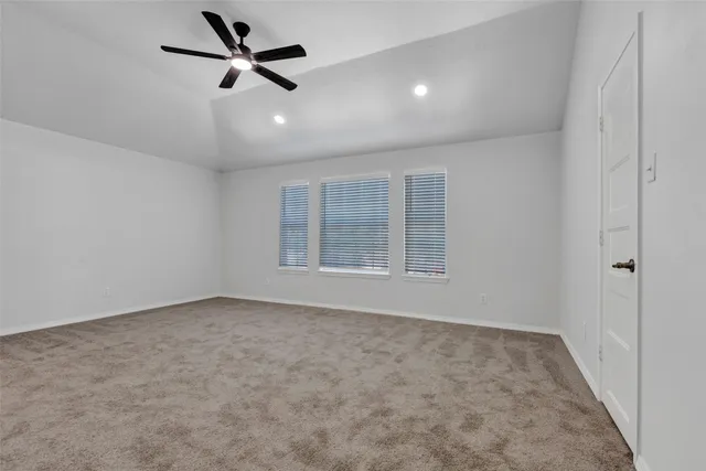 an empty room with a ceiling fan and window