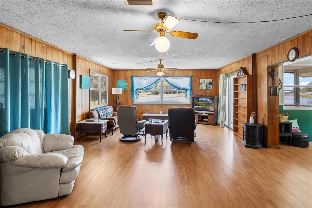 1226 South Telephone Point Road Inverness, FL 34450 - Photo 9 of 43 a living room with furniture a ceiling fan and a large window