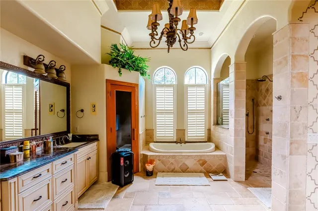 a spacious bathroom with a granite countertop tub and a large mirror