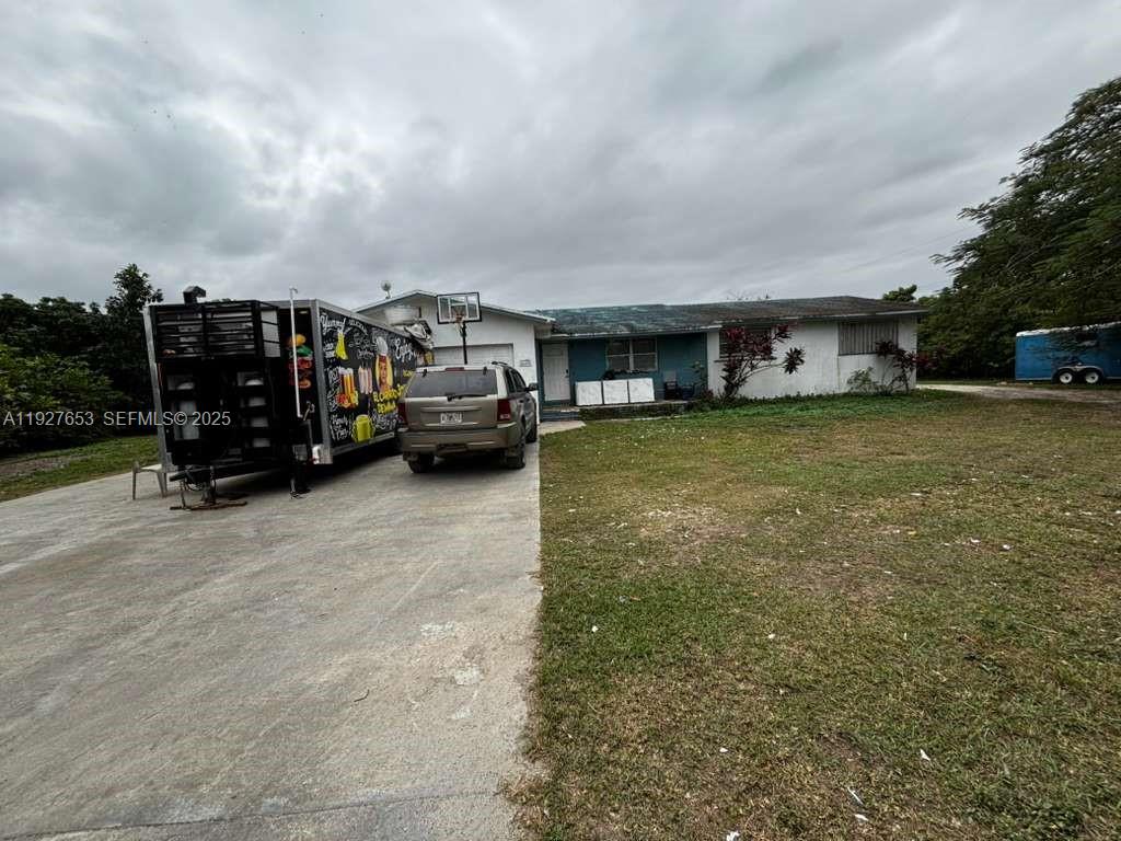 21160 Southwest 328th Street Homestead, FL 33030 - Photo 11 of 18 a view of a car park in front of a house