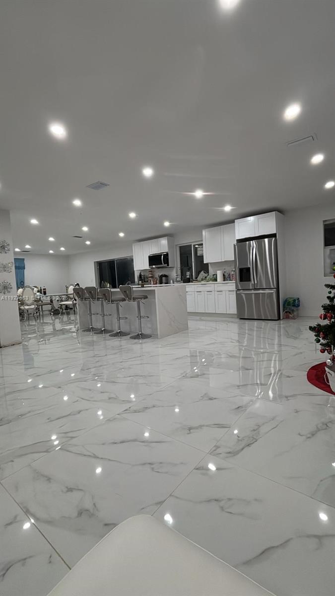 21160 Southwest 328th Street Homestead, FL 33030 - Photo 2 of 18 a view of a kitchen with kitchen island white cabinets and stainless steel appliances