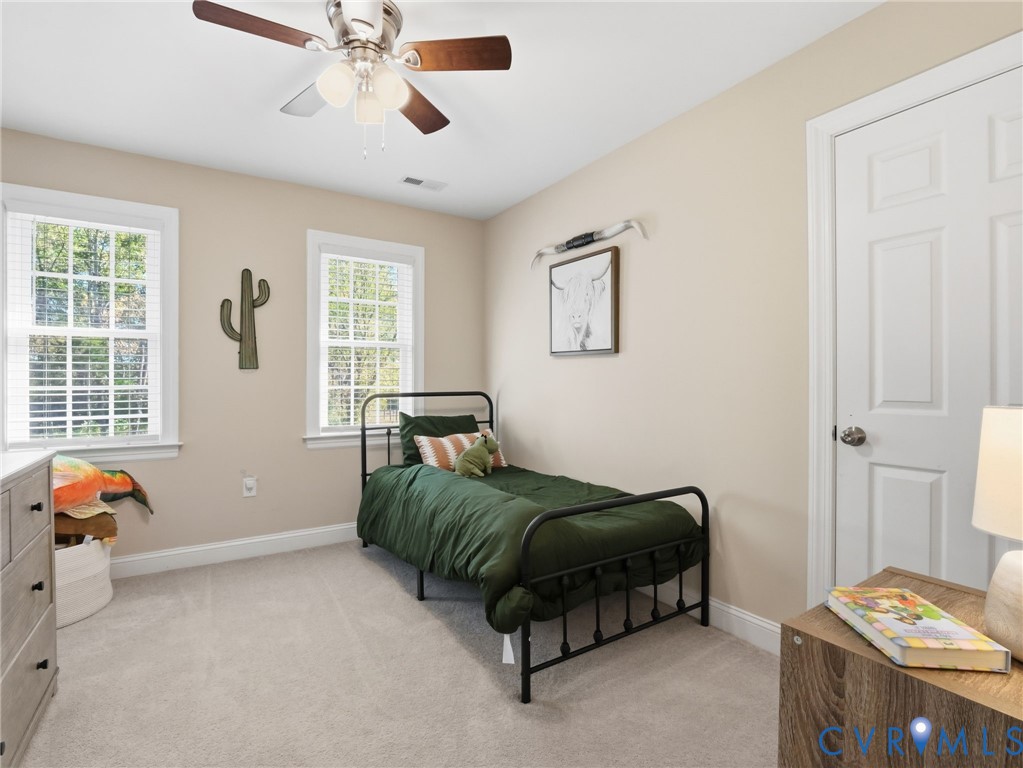 11084 West River Road Aylett, VA 23009 - Photo 21 of 36 a bedroom with a bed and a chandelier fan