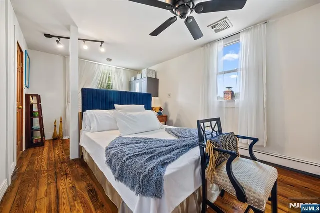 a bedroom with a bed and wooden floor