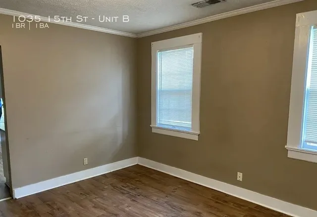 a view of a small space with wooden floor and a window
