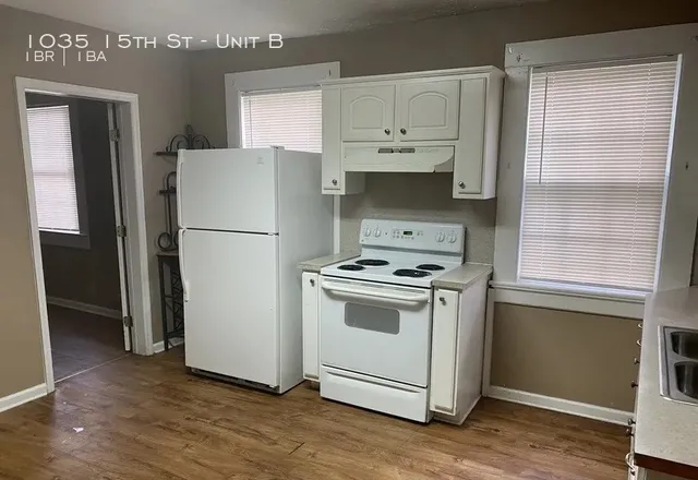 a white refrigerator freezer and a wooden floor