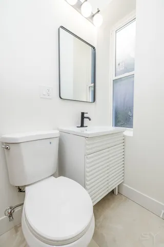 a bathroom with a toilet sink and mirror