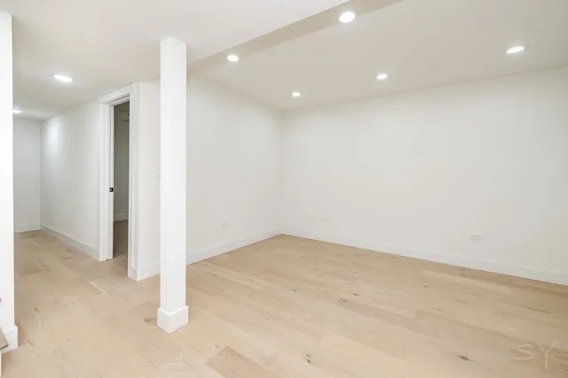 an empty room with a ceiling fan and wooden floor