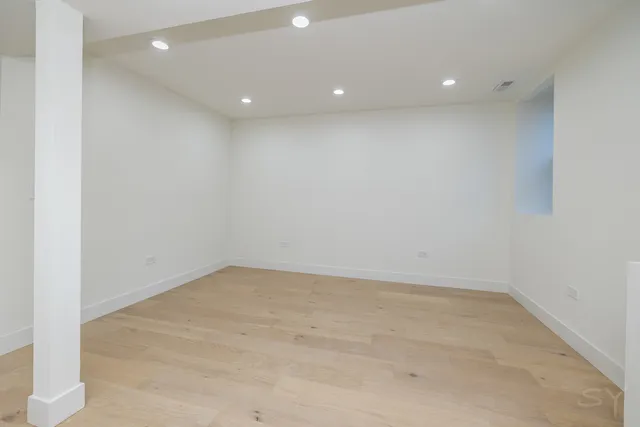 an empty room with a ceiling fan and wooden floor