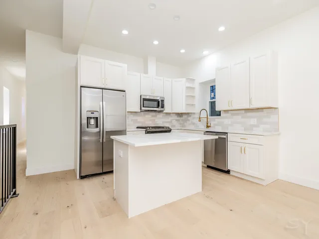 a kitchen with a refrigerator a sink and cabinets