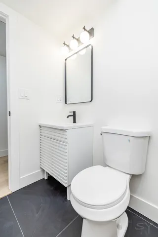 a bathroom with a toilet sink and mirror