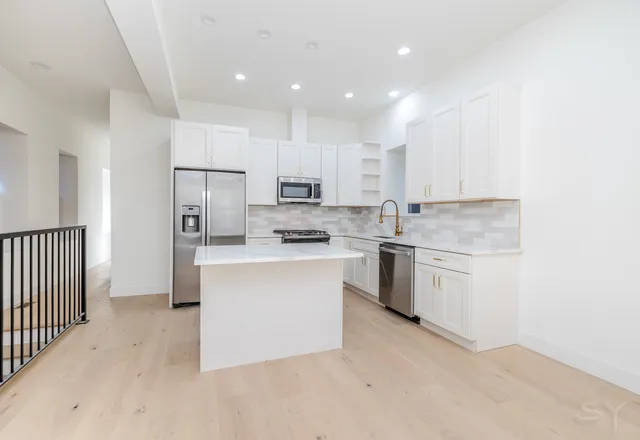 a kitchen with a refrigerator and a stove top oven