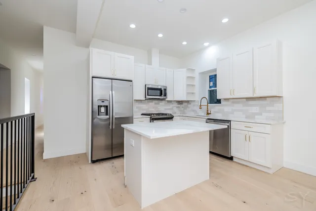 a kitchen with stainless steel appliances granite countertop a refrigerator stove microwave and sink