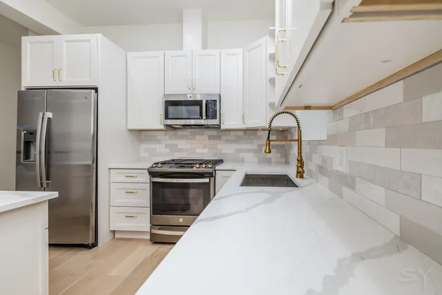 a kitchen with stainless steel appliances a stove microwave and refrigerator