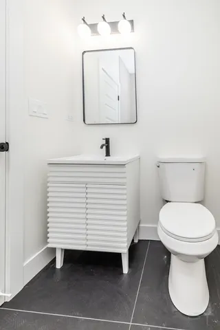 a bathroom with a toilet sink and mirror